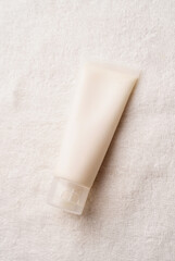 Top view Mockup facial skincare product white tube with blank label on farbic background