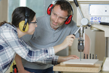 carpenter with female apprentice working on building site