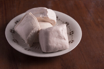 Tahu Putih or Tofu, a food raw material made from fermented soybean extract. Served on a white plate. Selective focus.
