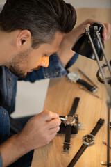 a watchmaker is fixing a watch