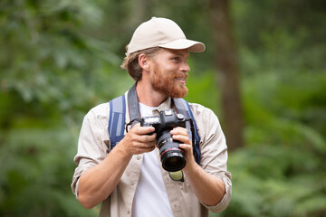 young photographer photographing in mountain valley