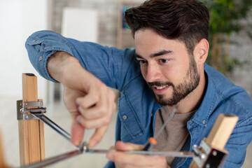 man putting together self assembly furniture in new home