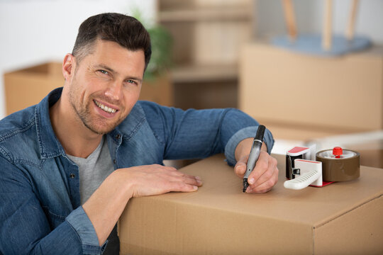 Young Man Packing Boxes To Move House