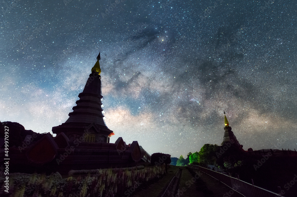Wall mural the milky way galaxy moving over a sacred temple at doi inthanon national park, chiang mai, thailand