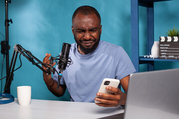 Portrait of influencer crying after reading on smartphone insulting comments from online social...