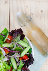 flat lay of homemade salad dressing with side salad on rustic table with copy space