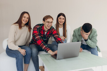 Group of friends looking at something on a laptop computer