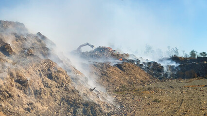 Burning pile of garbage at dump ground or landfill releasing toxic smoke in environment and...