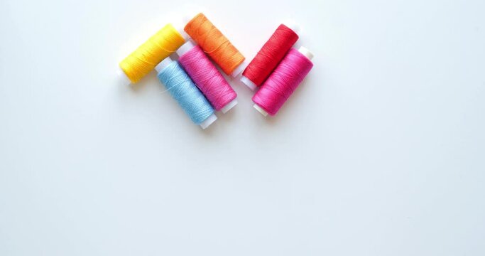 Multicolored spools of thread in shape of heart. 4K looped stop motion animation