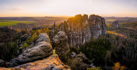 Male silhouette with raised arms on sharp mountain top. Sport life concept and outdoor activities....