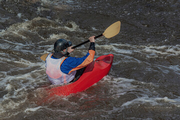 A series of images. Athletes in kayaks and kayaks conquer the stormy waters of the river. Dressed in waterproof clothes and helmets. They hold an oar in their hands. Motion blur