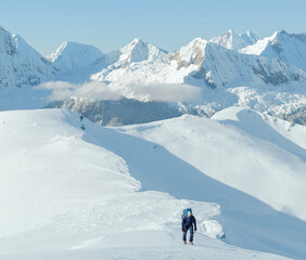 Fototapeta na wymiar Alpinist walking on snow in the mountains