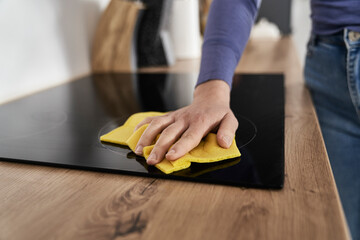 Close up of caucasian woman cleaning ceramic glass cooktop