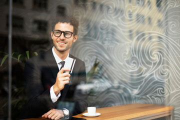 Handsome businessman enjoy in fresh coffee. Young man with credit card and phone