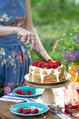 girl cuts biscuit with strawberries