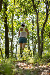 Woman runner running on forest trail