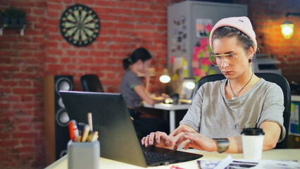 Hispter woman working on laptop in creative studio
