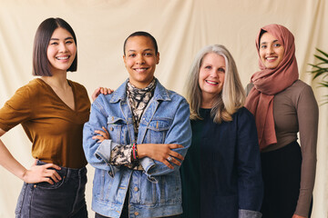 International Women's Day portrait of cheerful multiethnic mixed age range women smiling towards...