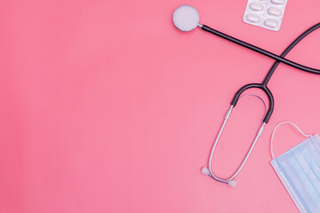 stethoscope on pink background and copy space