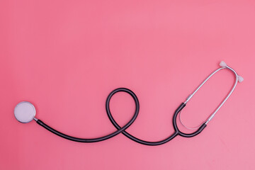 Fototapeta premium stethoscope on pink background and copy space