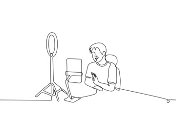 male blogger or celebrity live streaming using tablet and ring lamp - one line drawing vector. concept of live, online streaming on social networks, communication with subscribers or fans