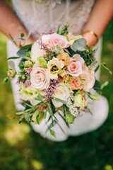 Braut hält auf einer Hochzeit einen Hochzeitsstrauß Blumen in den Händen