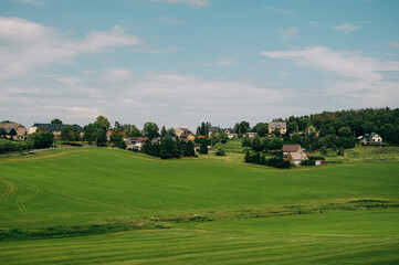 Fototapeta na wymiar Eine Landschaft mit Mittelsachsen mit grüner Wiese und kleinen Dörfern