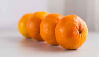 appetizing tangerines laid out in a row on white background
