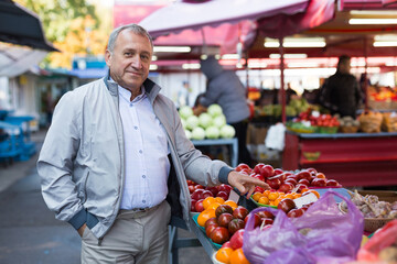 Man choosing vegetables in greengrocery