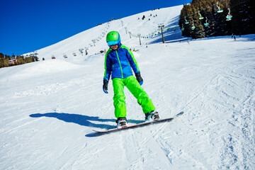 Fototapeta na wymiar Action photo of a snowboarder boy in motion on ski slope
