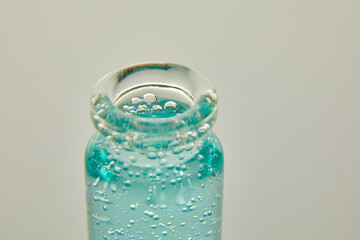 Close up of blue serum in a medical glass bottle, isolated on a white background, natural essential oil, cosmetic, medicine.