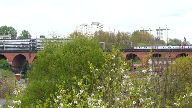 Two Opposite Direction Trains Meet On Famous Stockport Red Brick Viaduct In The Middle Of Town, Panning Shot.