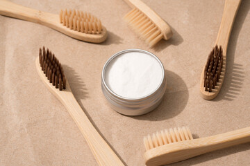 Natural wooden bamboo toothbrushes with natural bristle and mineral toothpowder on kraft paper background. Natural bath products, organic dentifrice. Mockup image, top view