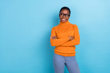 Photo of smart geek creative lady folded arms look empty space wear specs orange shirt isolated...