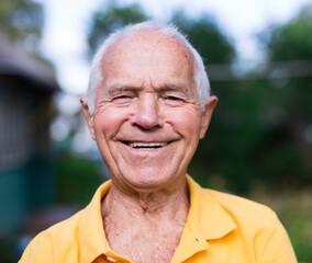 Portrait of an elderly man 70 years old in his garden on summer sunny day