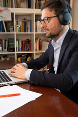 Businessman, wearing suit,
in video call with headphones. 