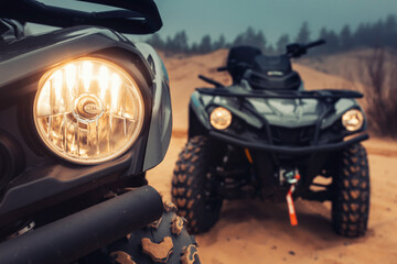 Headlight of quad bike at the middle of desert. Low beam of motorcycle is switched on