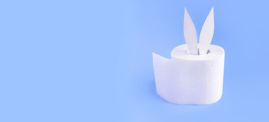 Bunny ears out of white toilet paper roll on pastel light blue background. Easter coronavirus...