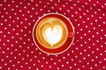 A hot latte  coffee in red cup on red polka dot background