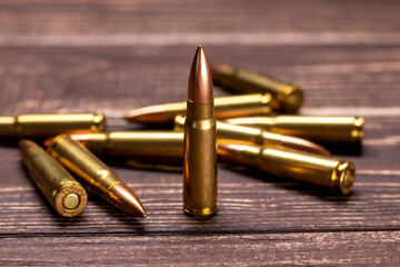 Bullets on wooden background. Cartridges 7.62 caliber for ak 47 closeup. Selective focus - obrazy, fototapety, plakaty