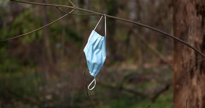 a protective mask against the virus thrown into nature making garbage