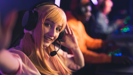 Selfie of young Caucasian female player in a wig and headphones smiling copy space players on the background . High quality photo