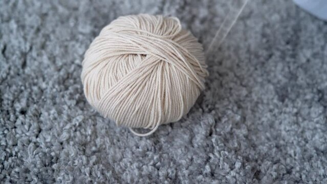 Skein of woolen threads for knitting with a hook in a female hand, close-up, hobby concept, knit