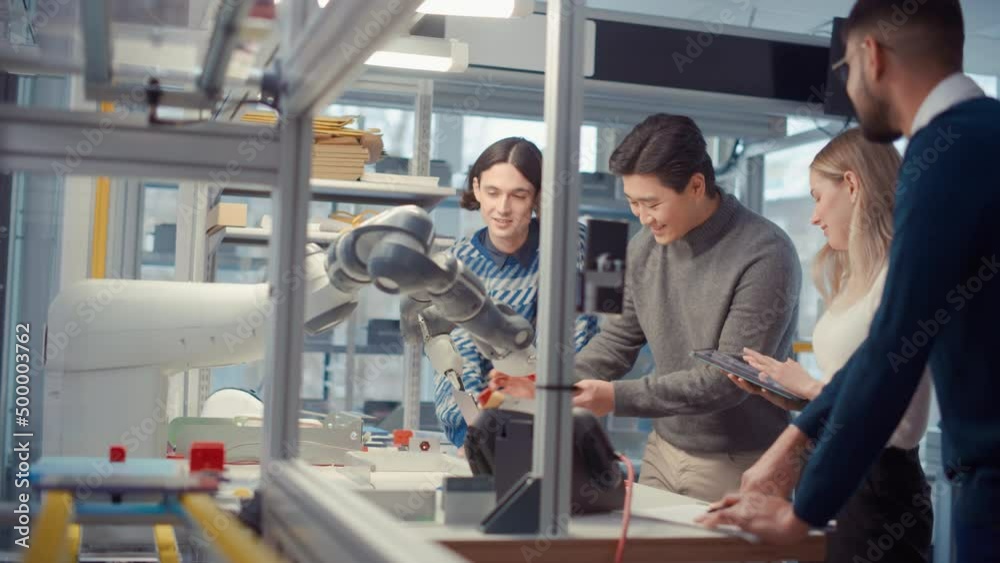 Poster young specialists touch details of robotic hand and smile during discuss. engineers try to make jobs