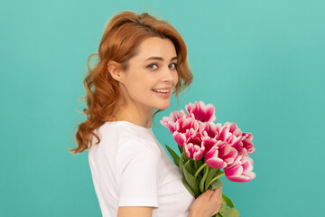 happy girl with tulip flower bouquet on blue background. mothers day