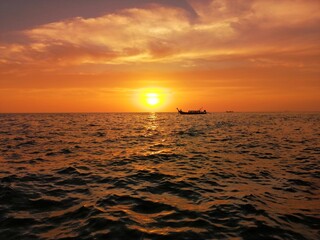 Fototapeta na wymiar Long-tail boat cutting the sunset on the Adaman sea