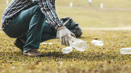 A man is picking up trash in a park, not throwing trash in the trash can ruin the beauty of the...