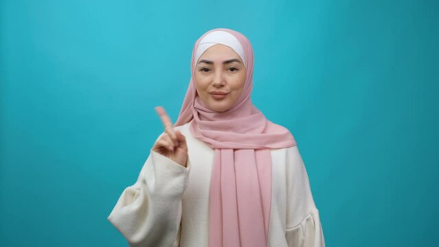 Young Muslim woman in hijab looking camera pointing fingers herself ask say who me no thanks i do not need it Isolated studio shot