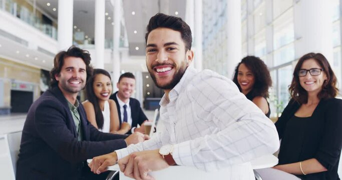 You become the best by first believing you can. Young businessman smiling in an office during a meeting with his colleagues. Diverse happy group of workers discussing a new project in a work meeting 