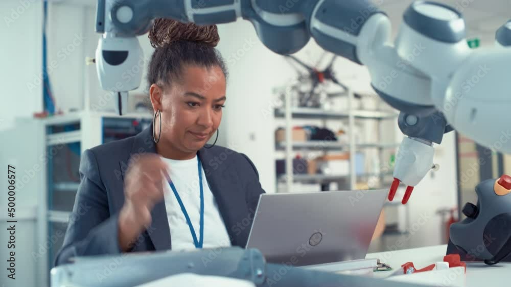 Poster portrait of female senior engineer works on engineering project, coding at laptop and changes robot 